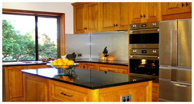 A Traditional American Oak Timber Kitchen with modern features such as Black Galaxy Granite tops, Stainless Steel Appliances and Glass Splashbacks, at Willunga by Adelaide’s Compass Kitchens